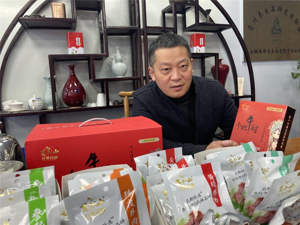 葛峰在介绍药膳产品。　　家传手艺做成药膳“省标”　　“从父亲手